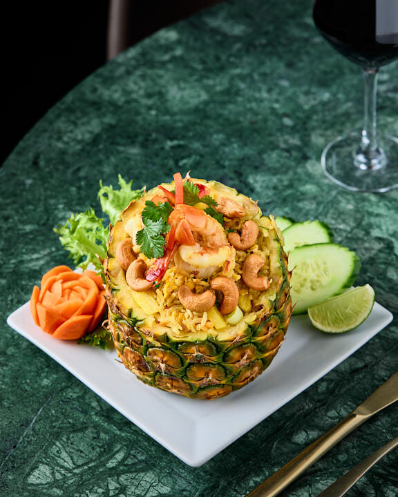 Riz sauté à l’ananas et aux crevettes avec noix de cajou et coriandre, présenté dans son ananas