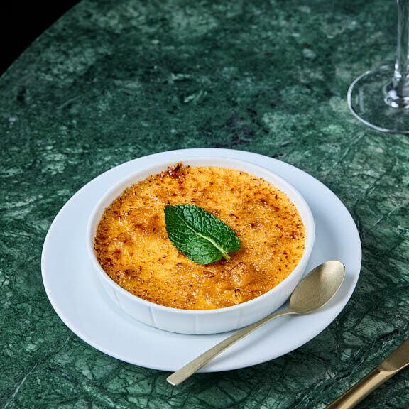 Crème brulée à l'ananas rôti avec une feuille de menthe