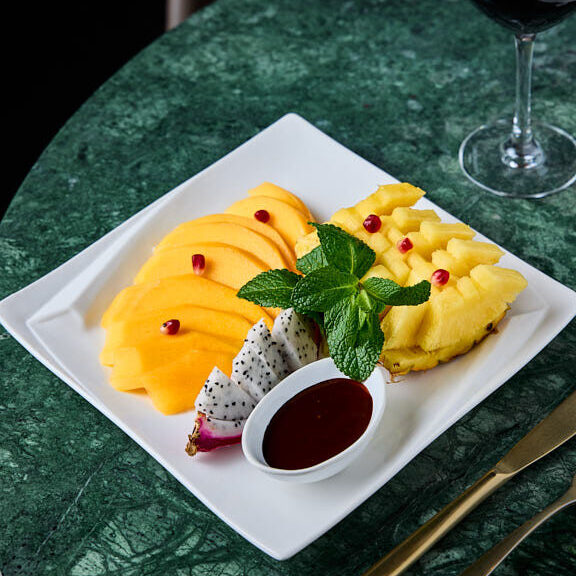 Assortiments de fruits exotiques, mangue, ananas, fruit du dragon, grenade, avec sa ganache