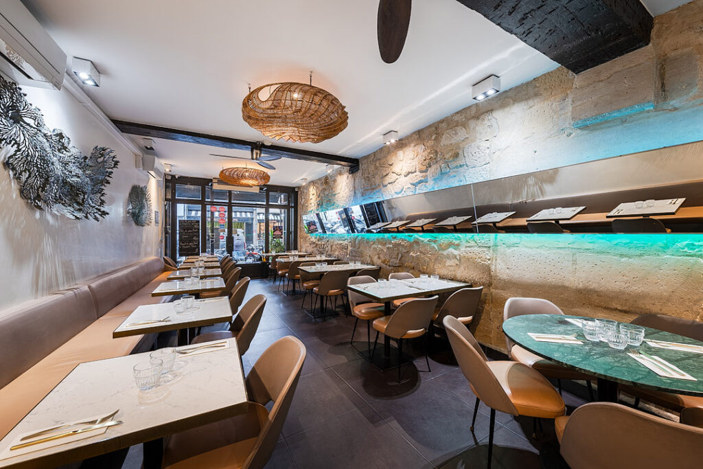 Intérieur du restaurant Suan thai avec tables dressées, décorations, et luminaires en osier.