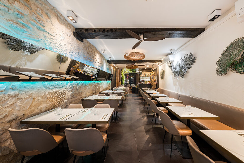 Intérieur du restaurant Suan thai avec tables dressées, décorations, et luminaires en osier.