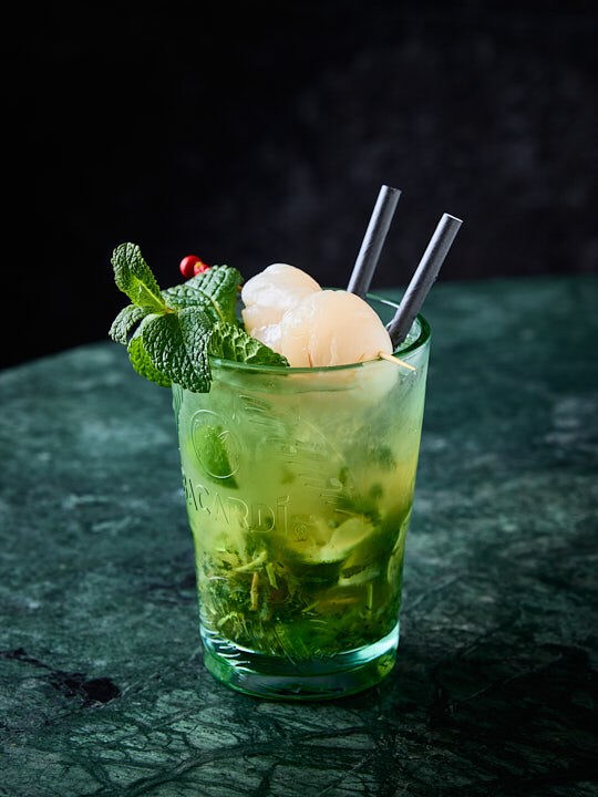 Cocktail Mojito litchi sur une table en marbre vert